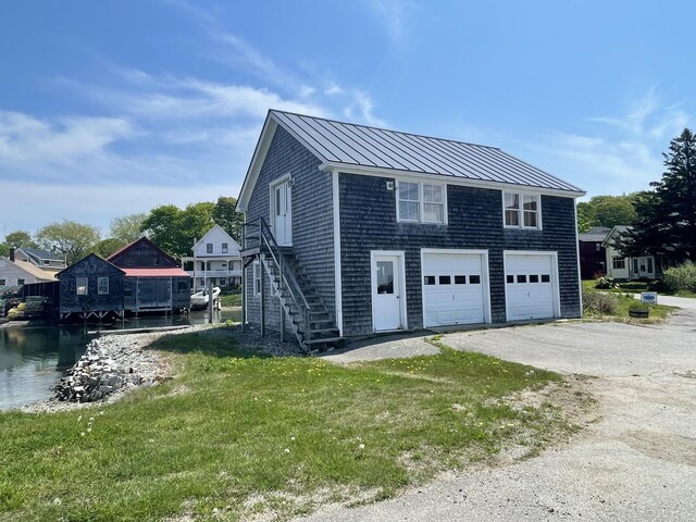27 Clamshell Aly, Vinalhaven, ME 04863 - view of side of property with a standing seam roof, a metal roof, a yard, and driveway