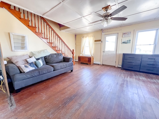 living room with hardwood / wood-style flooring, ceiling fan, and a baseboard heating unit