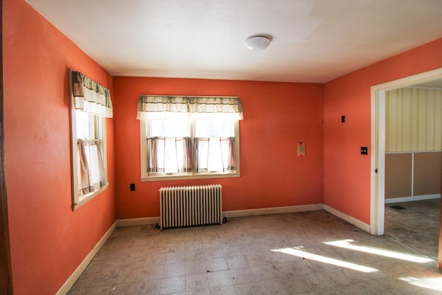 tiled empty room featuring radiator heating unit