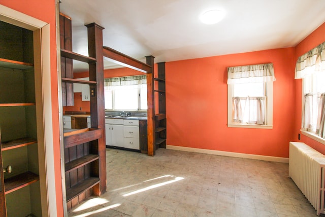 interior space featuring tile flooring, multiple windows, and radiator