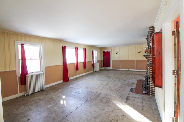 unfurnished room with brick wall, tile floors, and radiator