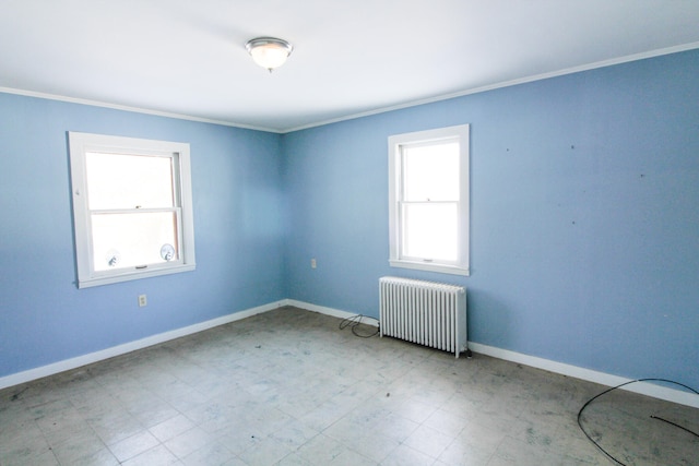 tiled spare room featuring ornamental molding and radiator