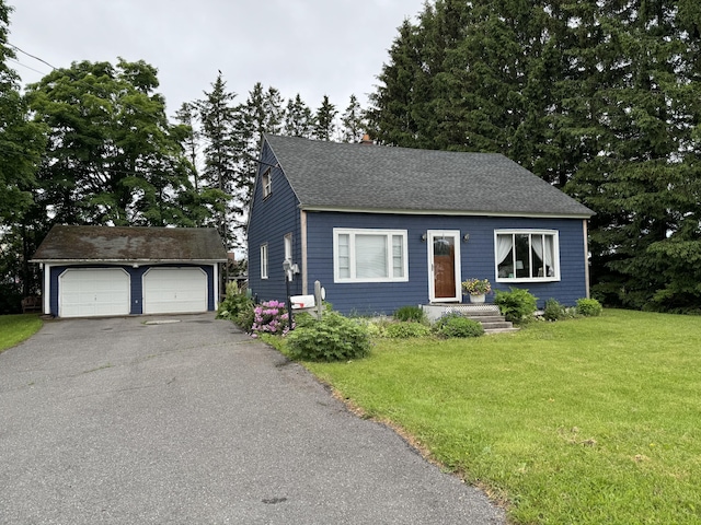 view of front of property with a front lawn, a garage, and an outdoor structure