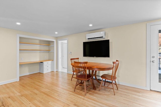 dining space with light hardwood / wood-style floors and a wall mounted air conditioner