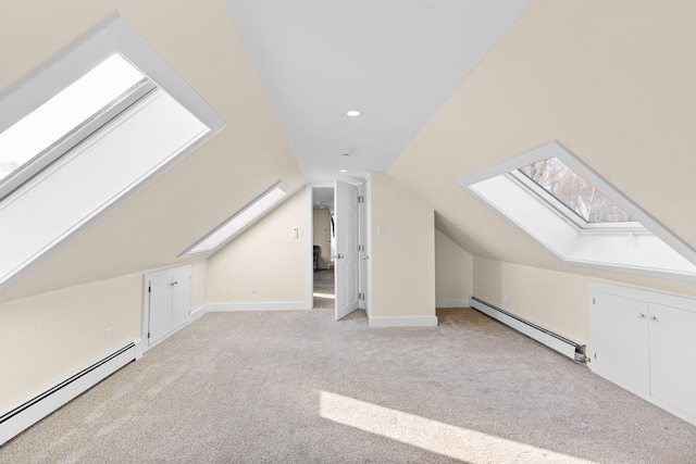 bonus room with lofted ceiling with skylight, light colored carpet, and a baseboard radiator