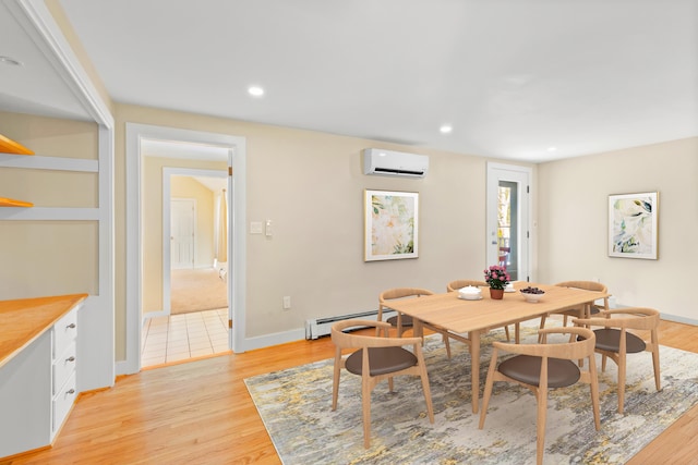 dining space featuring light hardwood / wood-style floors, a baseboard heating unit, and an AC wall unit