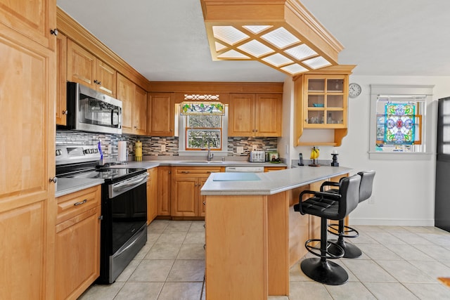 kitchen featuring a center island, sink, appliances with stainless steel finishes, a kitchen bar, and light tile patterned floors