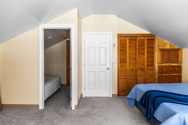 bedroom with light colored carpet, a closet, and lofted ceiling