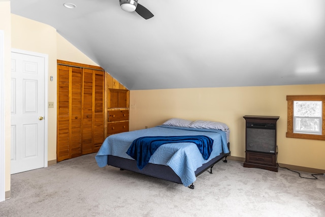 carpeted bedroom with vaulted ceiling, ceiling fan, and a closet