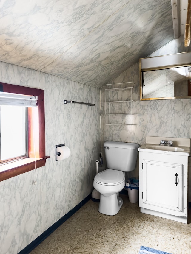 bathroom with lofted ceiling, vanity, toilet, and tile walls