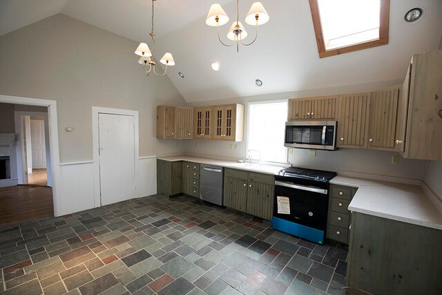 kitchen featuring pendant lighting, an inviting chandelier, a skylight, appliances with stainless steel finishes, and dark hardwood / wood-style flooring