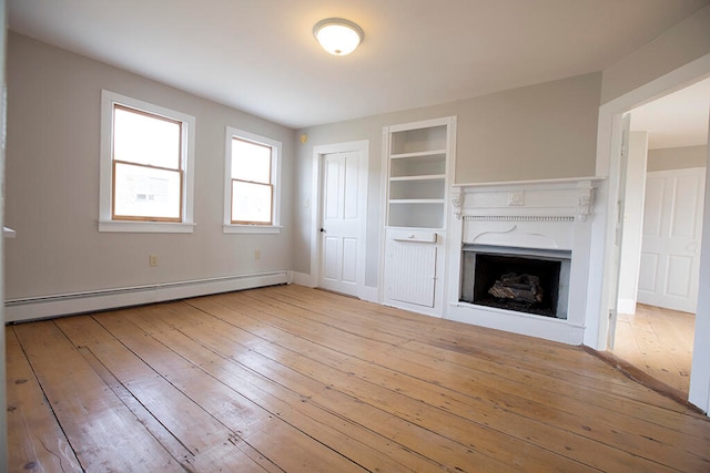 unfurnished living room featuring light hardwood / wood-style flooring and baseboard heating