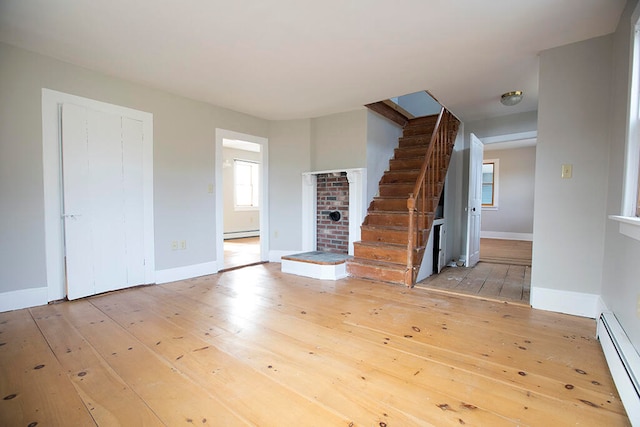 foyer entrance with wood-type flooring and a baseboard heating unit