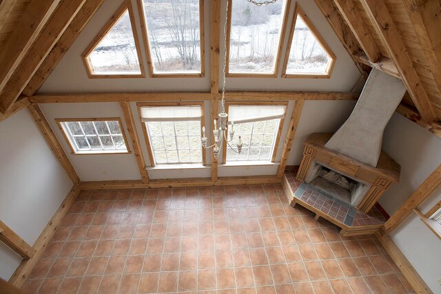 tiled living room featuring lofted ceiling and a chandelier