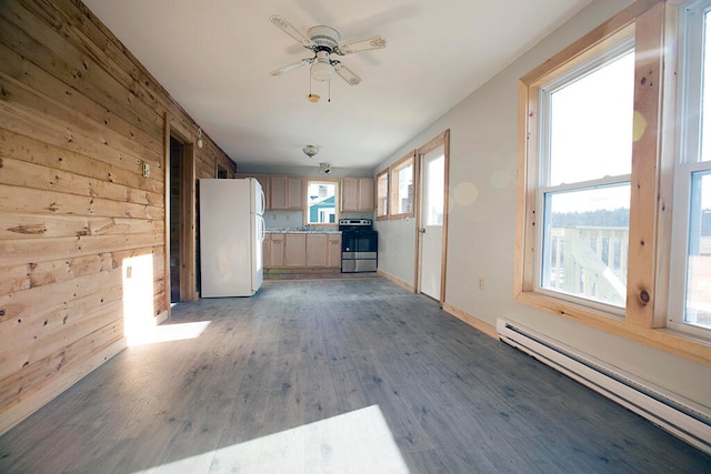 interior space with plenty of natural light, wood walls, a baseboard radiator, and hardwood / wood-style flooring