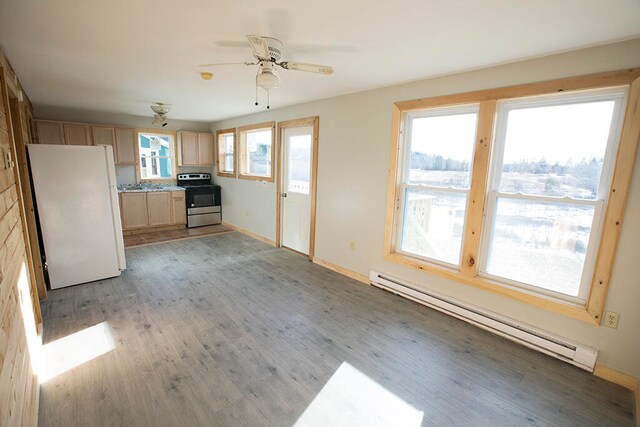 interior space with a baseboard radiator, ceiling fan, sink, and light wood-type flooring