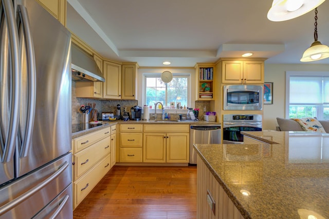 2 Maddox Pond Rd, Biddeford, ME 04005 - kitchen featuring appliances with stainless steel finishes, wall chimney range hood, light wood-style flooring, a raised ceiling, and tasteful backsplash