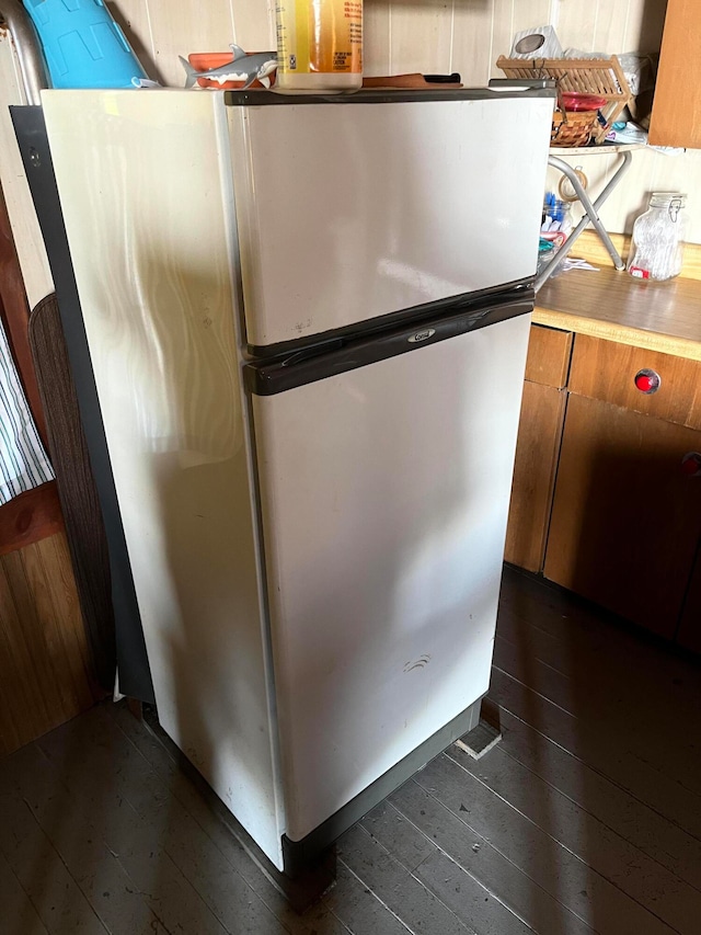 room details featuring stainless steel fridge and dark wood-type flooring