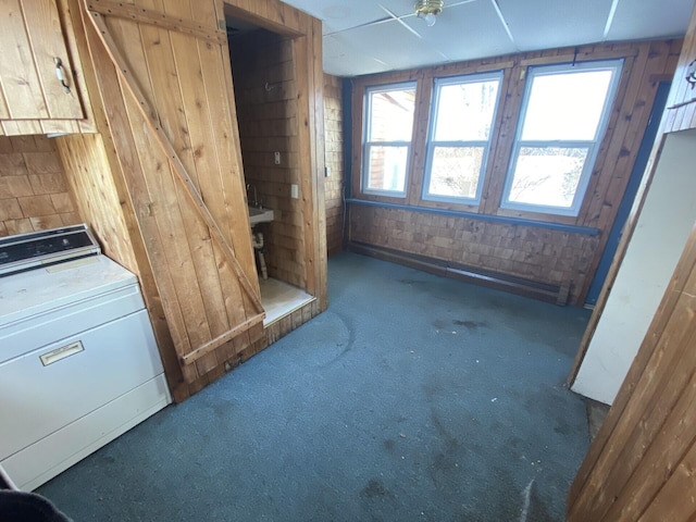 misc room featuring wood walls, washer / dryer, and dark carpet