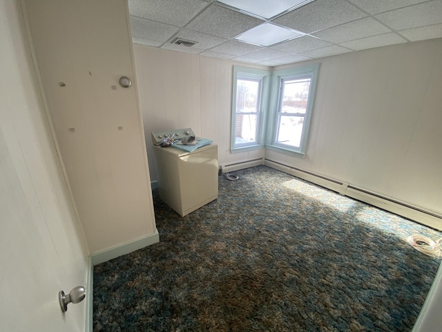 carpeted empty room featuring a paneled ceiling and washer / clothes dryer