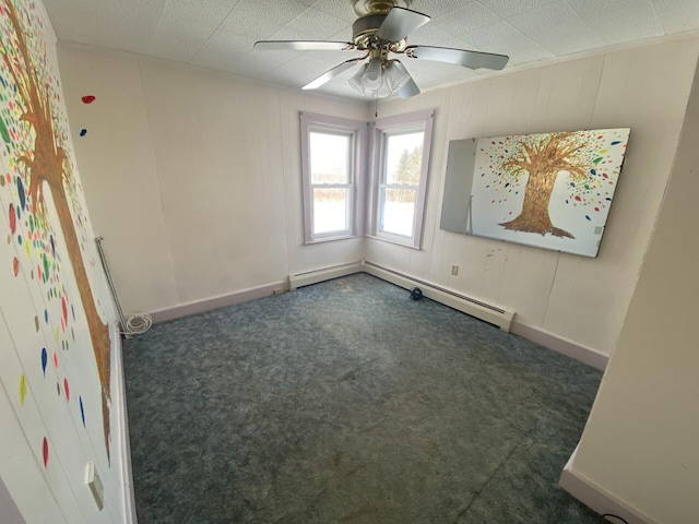 carpeted empty room with ceiling fan and a baseboard heating unit