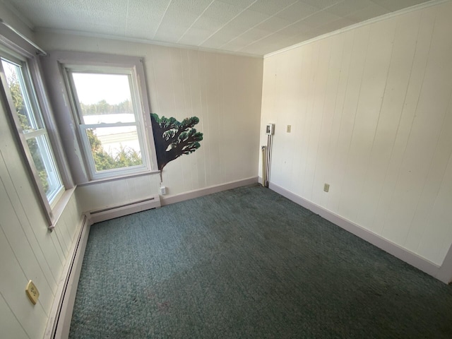 empty room featuring crown molding, a baseboard heating unit, and dark carpet