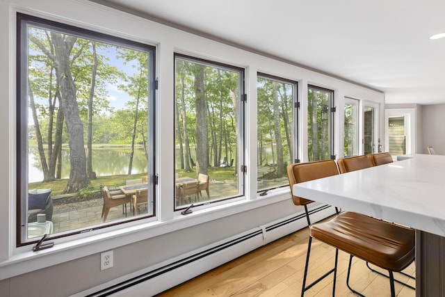 8 Hickory Ln, York, ME 03909 - dining area with a baseboard heating unit, a water view, and light wood-style flooring