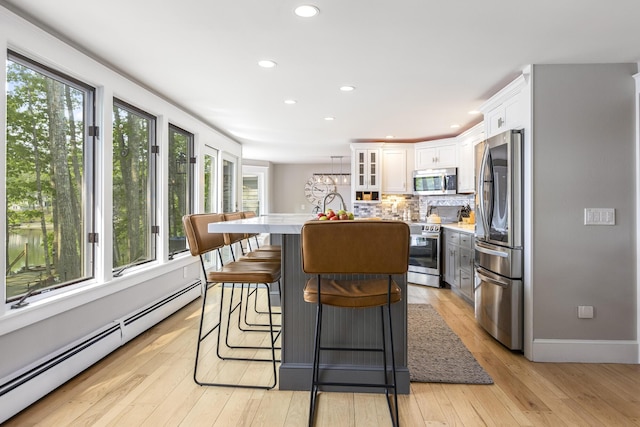 8 Hickory Ln, York, ME 03909 - kitchen featuring stainless steel appliances, baseboard heating, white cabinets, a kitchen island with sink, and light countertops