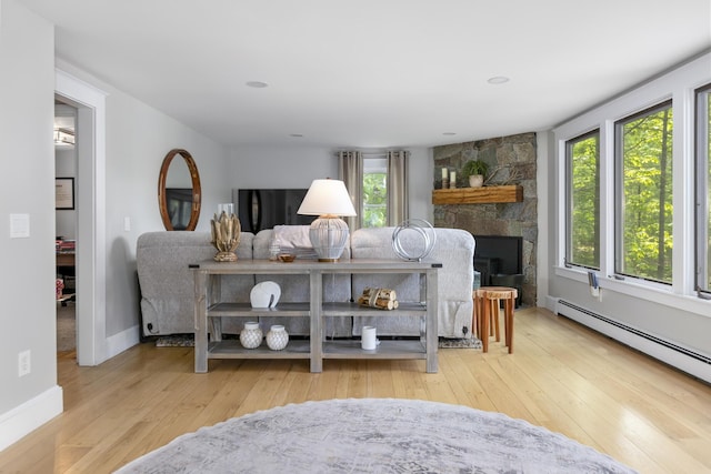 8 Hickory Ln, York, ME 03909 - living room featuring healthy amount of natural light, hardwood / wood-style floors, baseboard heating, and a stone fireplace