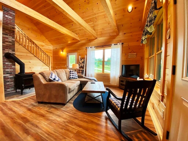 living room featuring wooden walls, a wood stove, brick wall, and light hardwood / wood-style floors