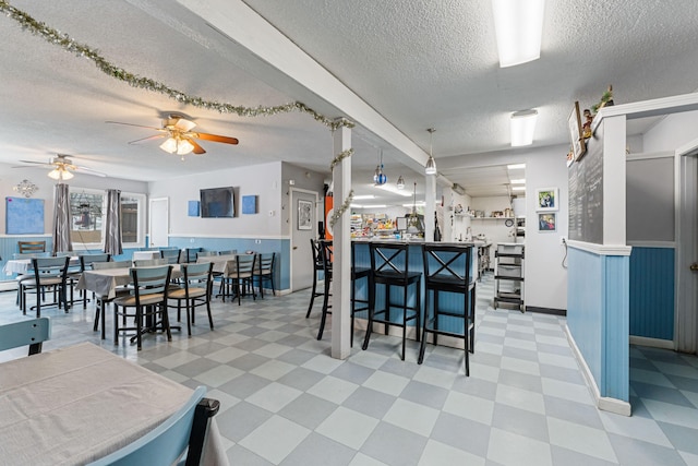 kitchen featuring a ceiling fan, tile patterned floors, and a textured ceiling