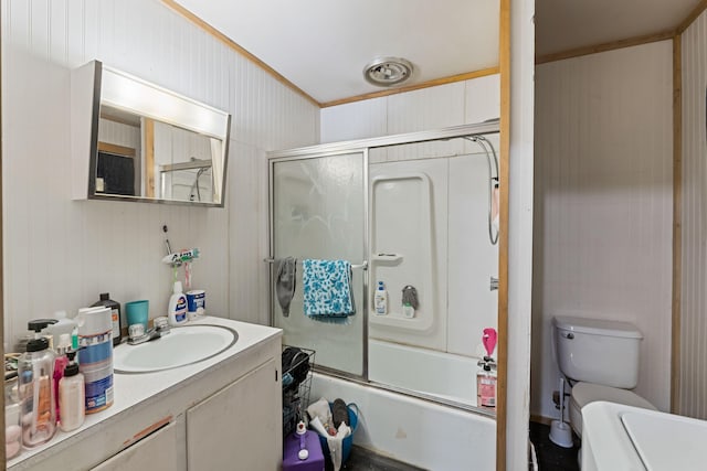 bathroom featuring toilet, bath / shower combo with glass door, and vanity