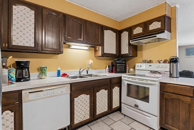 kitchen with white appliances, light countertops, a sink, and dark brown cabinets