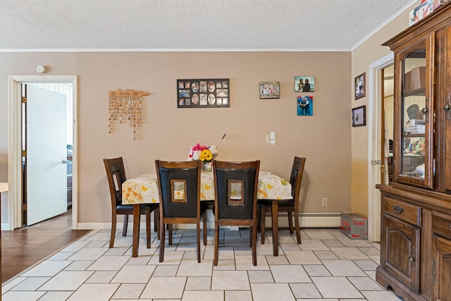 dining area with baseboards, baseboard heating, ornamental molding, and a textured ceiling