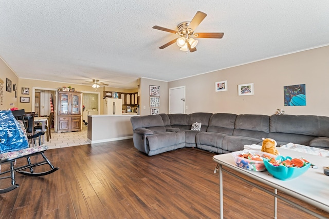 living area featuring hardwood / wood-style floors, a textured ceiling, and a ceiling fan