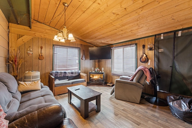 living room featuring vaulted ceiling, a chandelier, wood ceiling, wooden walls, and wood finished floors