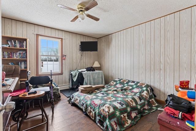 bedroom with a baseboard radiator, a textured ceiling, ceiling fan, and wood finished floors