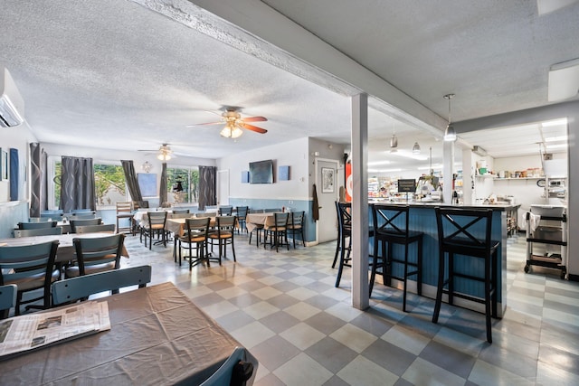 interior space with a ceiling fan, tile patterned floors, and a textured ceiling