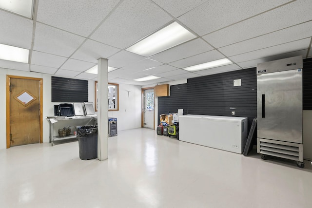 below grade area featuring high quality fridge and a paneled ceiling