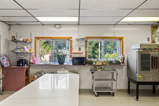 kitchen featuring black microwave, smart refrigerator, and a drop ceiling
