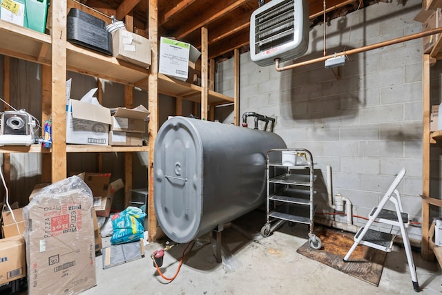 unfinished basement with concrete block wall and heating fuel