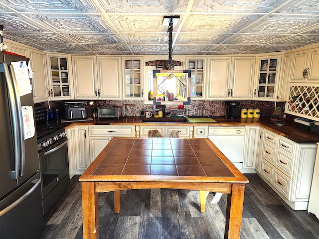 kitchen with dishwasher, stainless steel fridge, sink, stove, and decorative light fixtures