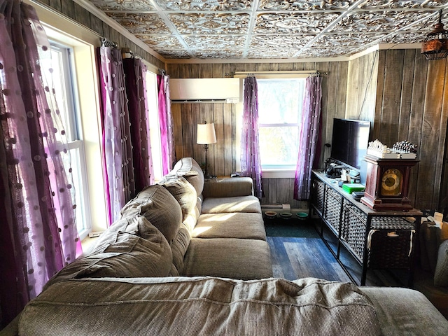 living room with wood walls, dark hardwood / wood-style flooring, and ornamental molding