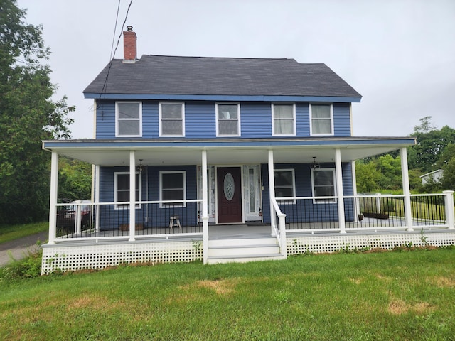 country-style home featuring covered porch and a front yard