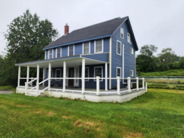 rear view of house featuring a lawn