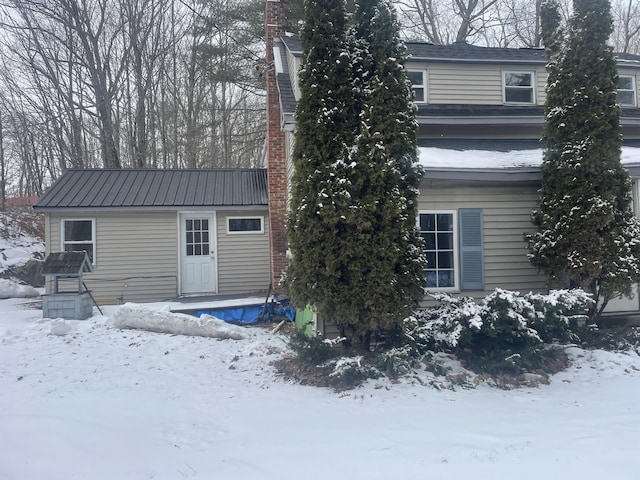 view of snow covered back of property