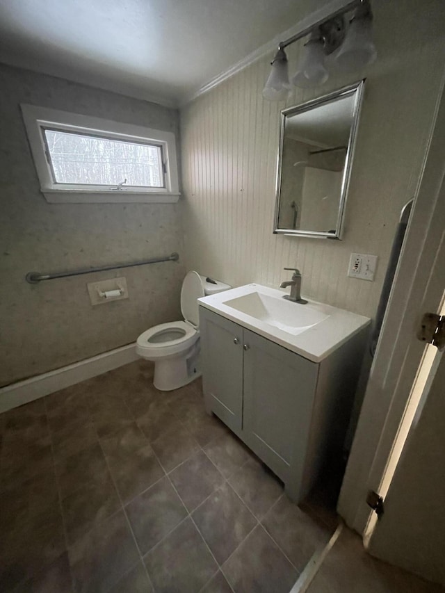 bathroom featuring toilet, tile flooring, ornamental molding, and vanity