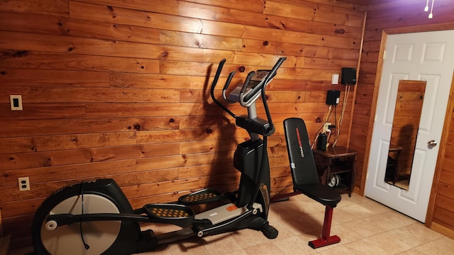 workout area with wooden walls and light tile floors