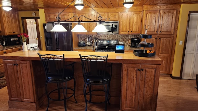 kitchen with black refrigerator with ice dispenser, range with electric stovetop, hardwood / wood-style flooring, and wood ceiling