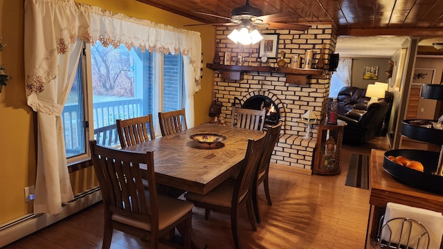 dining space with hardwood / wood-style flooring, baseboard heating, wood ceiling, and a brick fireplace